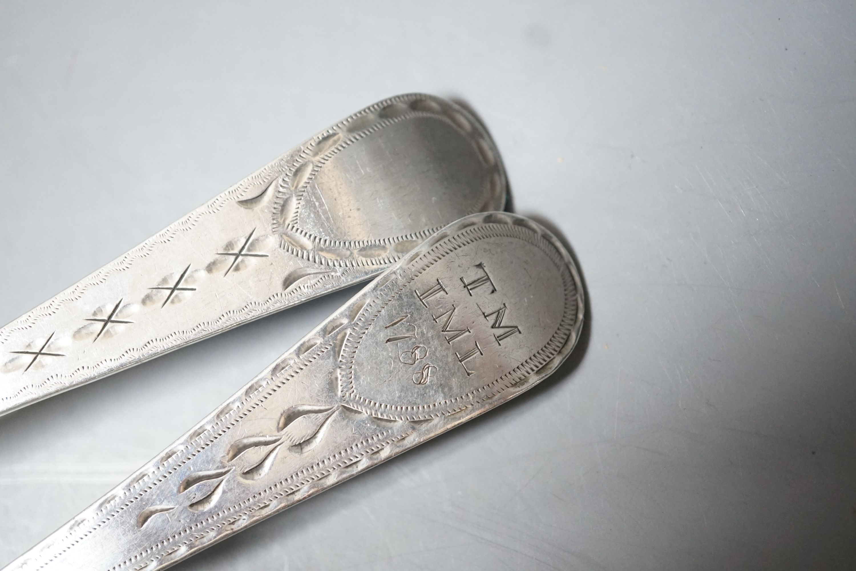 A near pair of George III provincial silver Old English pattern table spoons, by Richard Ferris, Exeter, 1791, with differing bright engraving and one with engraved date and initials, 21.4cm, 110 grams